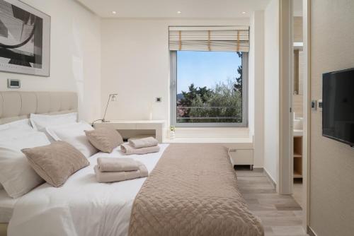 una camera da letto con un grande letto bianco e una finestra di New! Villa Vita Adele pool sauna jacuzzi sea view a Dubrovnik