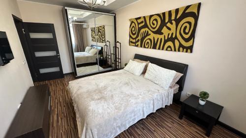 Un dormitorio con una cama grande y un espejo. en Comfortable flat in center, en Bishkek