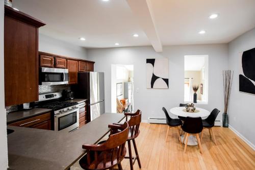 a kitchen with a table and chairs and a kitchen with a stove at Cozy Home with Backyard & Fire Pit in West New York