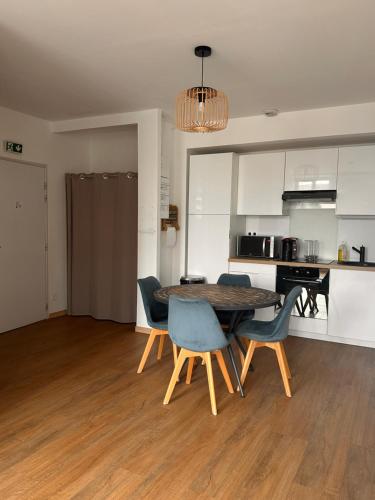 une cuisine et une salle à manger avec une table et des chaises dans l'établissement Le coudois, à Coudes