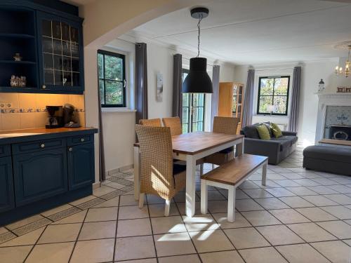 a kitchen with a table and chairs and a living room at Buitenplaats Villa Deluxe in Callantsoog