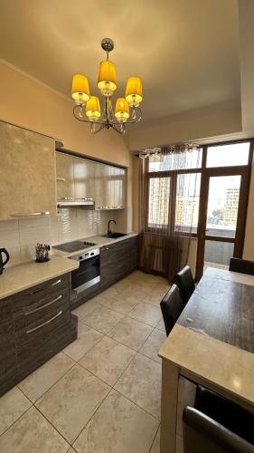Una gran cocina con una mesa y una lámpara de araña. en Comfortable flat in center, en Bishkek