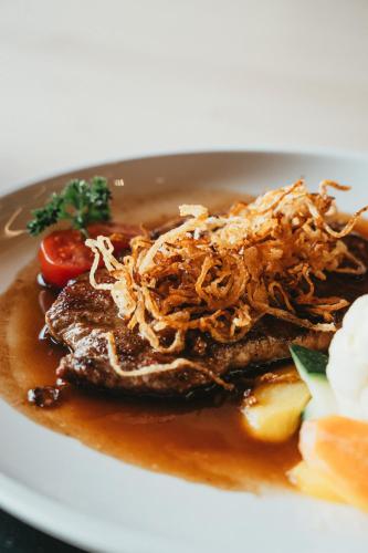 a plate of food with meat and tomatoes on it at Peterhof Chalets in Batschuns