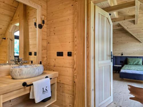 a bathroom with a sink in a log cabin at LK Forest Villa luksusowe domy z basenem z jacuzzi, sauną, grotą solną, salą bilardową i ogrodem in Łapsze Niżne
