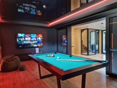 a pool table in a room with a tv at LK Forest Villa luksusowe domy z basenem z jacuzzi, sauną, grotą solną, salą bilardową i ogrodem in Łapsze Niżne