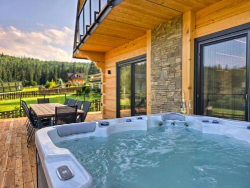 a hot tub on the patio of a house at LK Forest Villa luksusowe domy z basenem z jacuzzi, sauną, grotą solną, salą bilardową i ogrodem in Łapsze Niżne