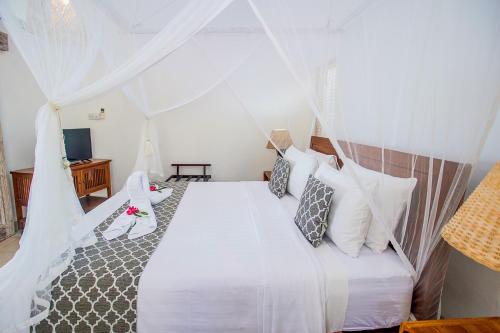 a bedroom with a bed with white sheets and pillows at Villa Lanie Lembongan in Nusa Lembongan