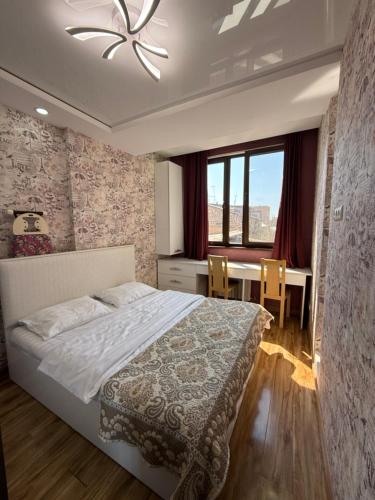 a bedroom with a bed and a table and a window at Apartment in Tumanyan street in Yerevan