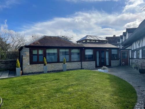 a house with a lawn in front of it at Little Monks Suite in Offenham