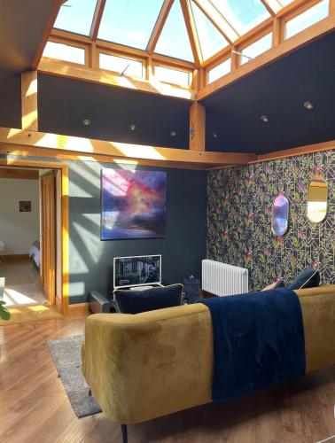 a living room with a couch and a tv at Little Monks Suite in Offenham