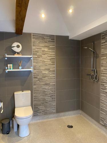 a bathroom with a toilet and a shower at Little Monks Suite in Offenham