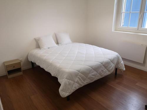 un lit blanc dans une chambre avec une fenêtre dans l'établissement Le Cosy de Paray 4 couchages, à Paray-le-Monial