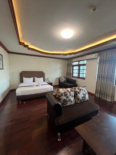 a living room with a bed and a couch at Nakhone Champa Hotel in Pakse