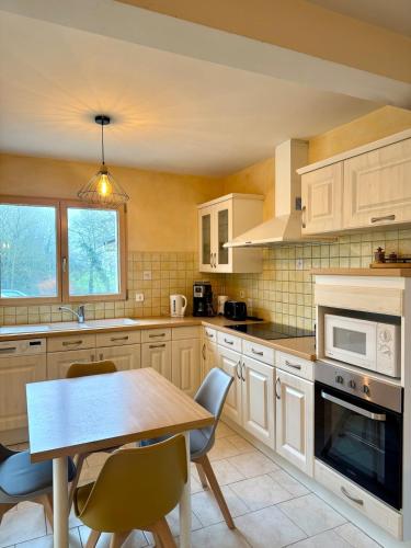 une cuisine avec une table en bois et une salle à manger dans l'établissement Jolie maison - 15 Mins des plages, à Pleslin-Trigavou