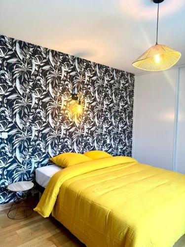 - une chambre avec un lit jaune et un mur noir et blanc dans l'établissement Jolie maison - 15 Mins des plages, à Pleslin-Trigavou