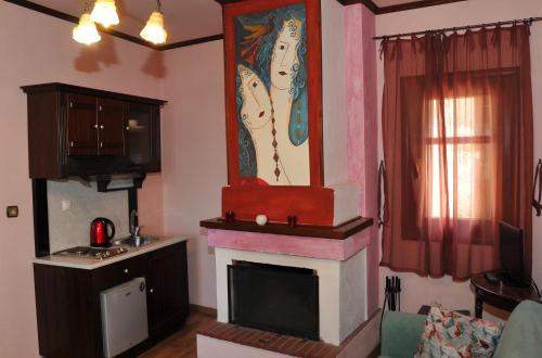 a living room with a fireplace and a painting on the wall at Archontiko Mesohori Meteora in Kalabaka