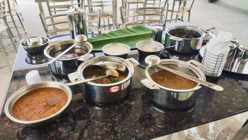 a bunch of pots of food on a table at The Valley Rose Farmstay in Yercaud