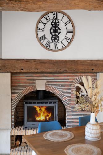 - une cheminée dans une salle à manger avec une table et une horloge dans l'établissement La Goélette - Entre Port & Plage - Cosy, à Dieppe