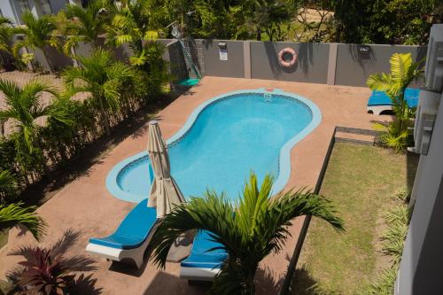 an overhead view of a swimming pool with an umbrella at Palm Holiday Apartments in Grand'Anse Praslin
