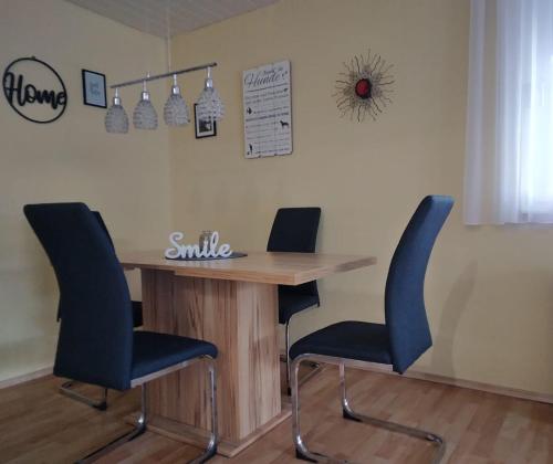 a table with two chairs and a smile sign on the wall at Haus Lucky in Rosenau am Hengstpass
