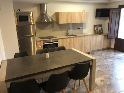 a kitchen with a table and chairs and a refrigerator at Casa FOR in Labuerda
