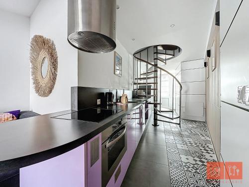 une cuisine avec un comptoir et un escalier en colimaçon dans l'établissement Le Lumicene, à Wimereux