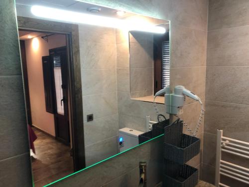 a bathroom with a large mirror and a sink at Casa FOR in Labuerda