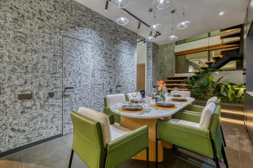 a dining room with a table and green chairs at Loyo Villas in Tegalalang