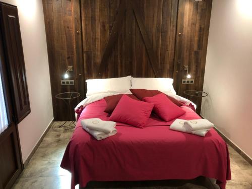 a bedroom with a bed with red sheets and pillows at Casa FOR in Labuerda
