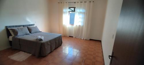 a small bedroom with a bed and a window at Casa Ponte Serrada in Joinville