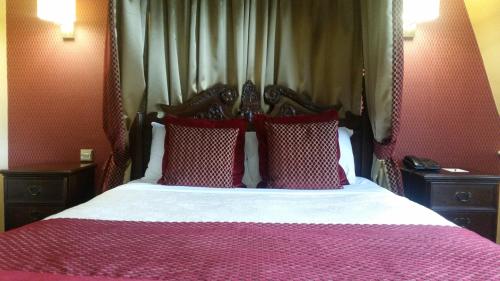 a bedroom with a bed with red and white pillows at Carlton Park Hotel Rotherham in Rotherham