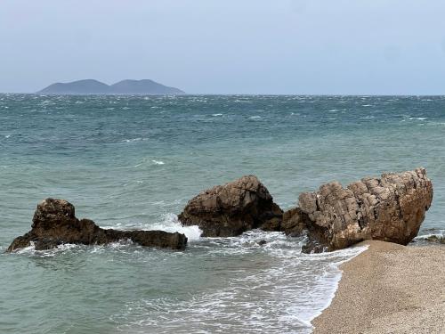 a group of rocks in the water on a beach at Vila Rahmi & Veli Dervishaj in Vlorë