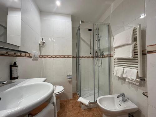 a white bathroom with a sink and a shower at Hotel President Venezia in Mestre