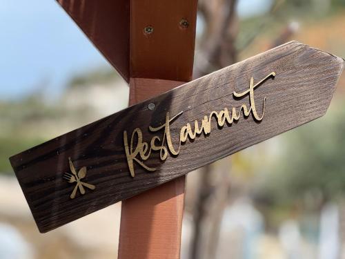 a wooden sign with the word reikiwana on a wooden pole at Vila Rahmi & Veli Dervishaj in Vlorë