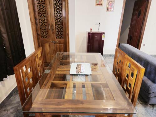 a glass table and chairs in a living room at Bricknest hillview in Mysore
