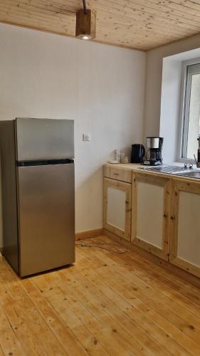 une cuisine avec un réfrigérateur en acier inoxydable et du parquet dans l'établissement Appartement Elielo, à Étival-Clairefontaine
