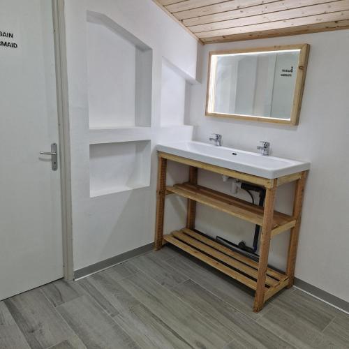 une salle de bain avec un lavabo et un miroir dans l'établissement Appartement Elielo, à Étival-Clairefontaine