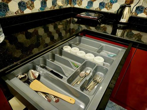 a kitchen drawer with silver utensils in it at Bricknest hillview in Mysore