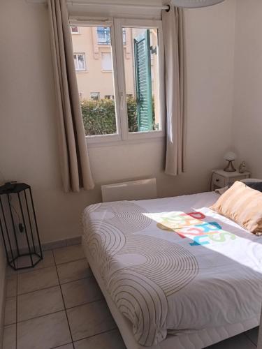 un lit dans une chambre avec une fenêtre dans l'établissement T3 rez-de-chaussée lumineux avec terrasse proche plage, à Cucq
