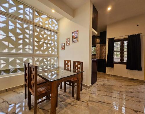a dining room with a table and chairs and a window at Bricknest hillview in Mysore