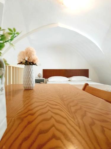 Un dormitorio con una mesa con un jarrón con flores. en Dimora Artus - Home Salento com, en Ugento