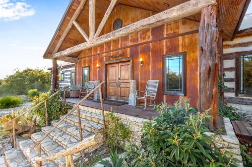 a log cabin with a porch and rocking chairs at Relics Reserve in Wimberley