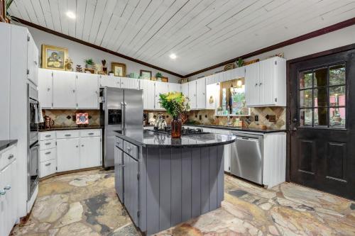 a large kitchen with white cabinets and a large island at Relics Reserve in Wimberley