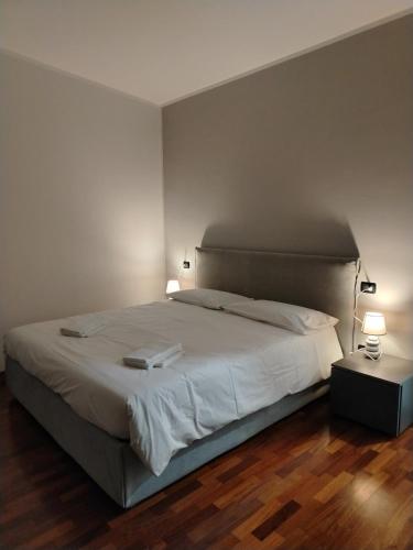 a bedroom with a large white bed with two lamps at Stay&Go - Bilocale con Giardino in Pregnana Milanese