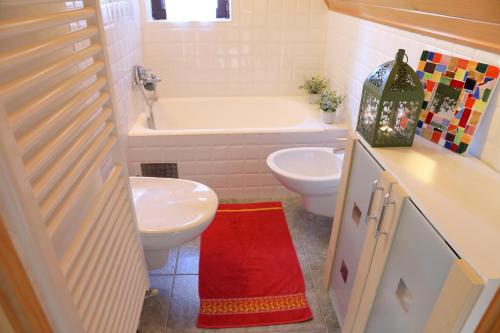 a bathroom with a tub and a toilet and a sink at Sanjska Hiša Vojsko in Idrija