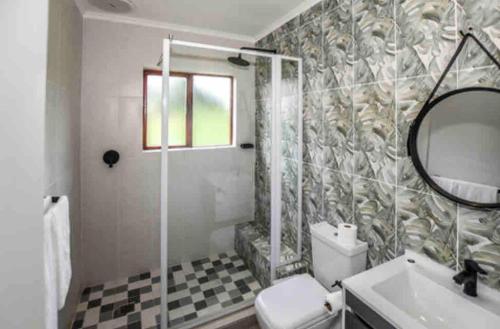 Un baño con ducha, inodoro y lavabo. en Peace and Comfort - Greenway Woods, en White River