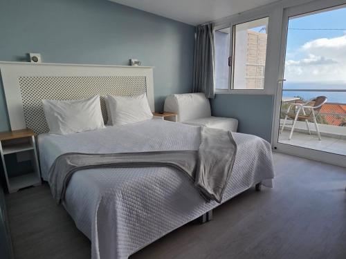 a bedroom with a bed and a view of the ocean at Canto da Manu Panoramic in Calheta