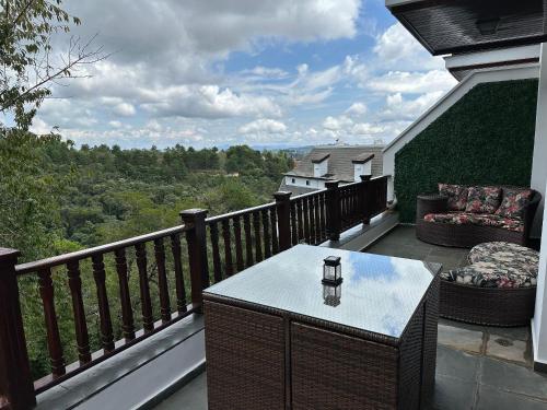 a balcony with a table and a chair with a view at Flat para 6 pessoas no Home Green Home in Campos do Jordão
