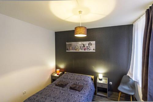 a small bedroom with a bed and a lamp at La Curiosité - Appartement 2 chambres à Barr, Route des Vins d'Alsace in Barr
