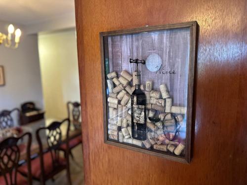 a door with a bottle of wine and a pile of fire wood at Flat para 6 pessoas no Home Green Home in Campos do Jordão